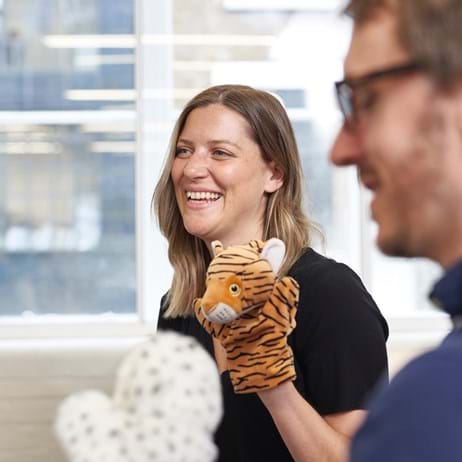 People using puppets to train in counselling & smiling