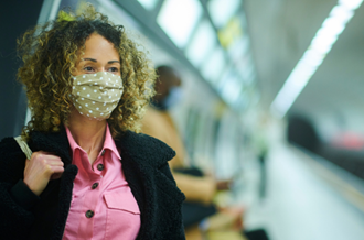 Woman wears facemask on the train platform