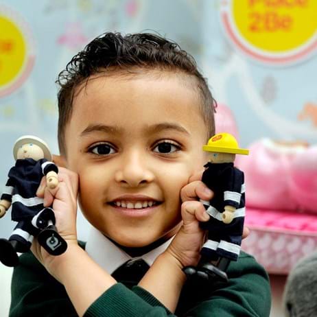 child holding firefighters toys in school therapy room