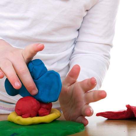 Child playing with multicolored Play-doh