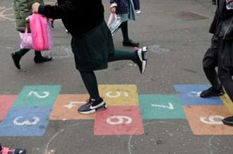 child playing on a hopscotch in a school playground