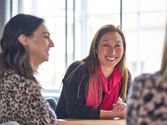 woman smiling and talking to colleagues