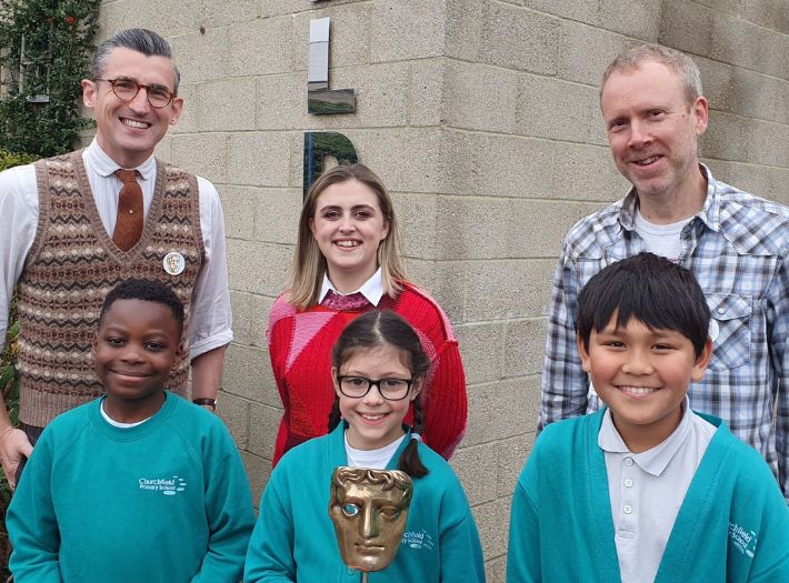 BAFTA Roadshow hosts Ben Shires (left) and Kia Pegg (centre), and guest speaker from Moonbug Entertainment Dan Balaam standing with Churchfield Primary School students. 