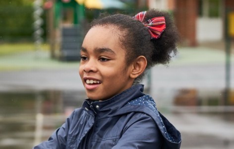 Young girl smiling in a school playground