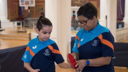 A woman and a child preparing to play table tennis