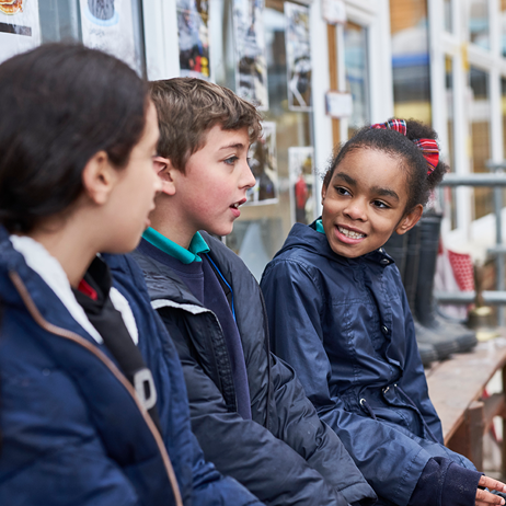 Children chatting on bench in playground