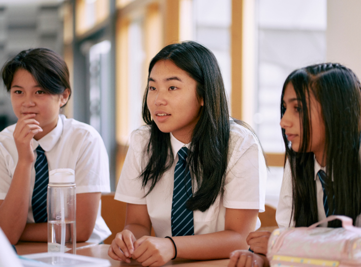 Three secondary school pupils listening in a lesson
