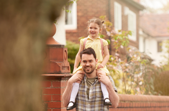 Girl in school uniform getting a piggy back from her father