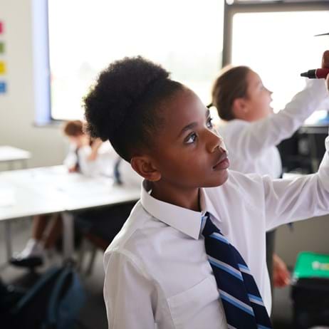 Young person writing on white board