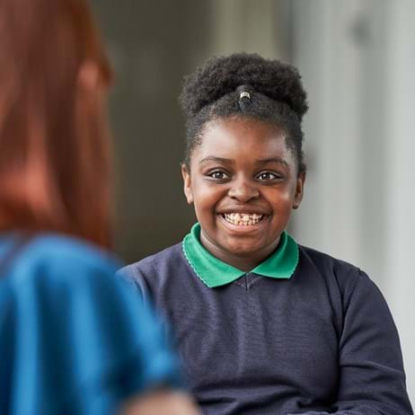 Counsellor with child who is smiling in school