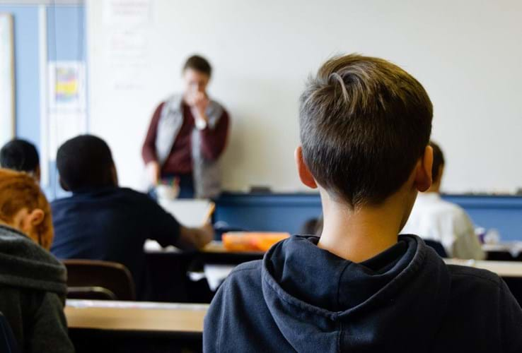 school pupil sat at classroom desk