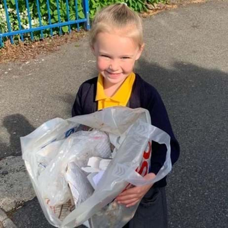 young girl showing the litter she picked up to raise money for Place2Be