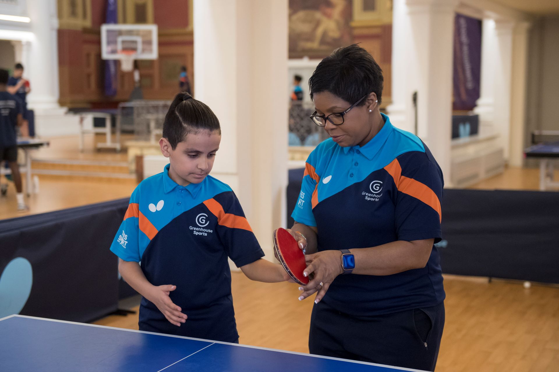 A woman and a child preparing to play table tennis