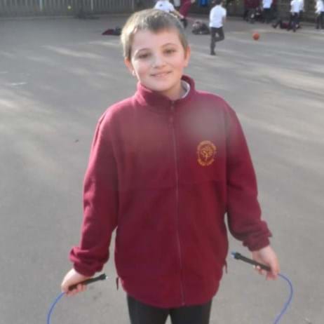 young boy holding skipping rope