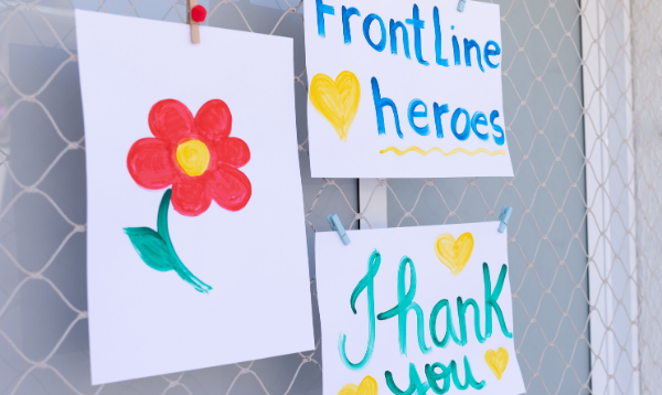 Artwork stuck to a window - a drawing of a flower, a drawing that says 'frontline heroes' and another that says 'thank you'