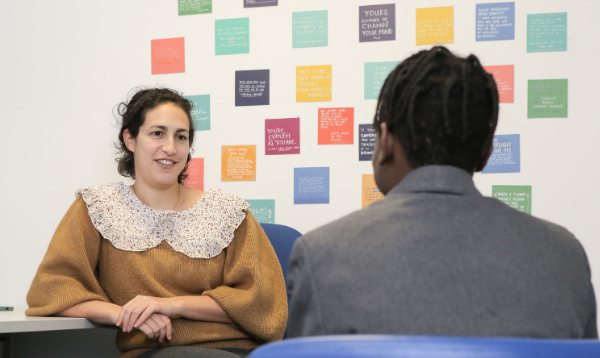 Counsellor and student talk in front of decorated wall