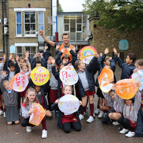 Teacher and children holding up signs