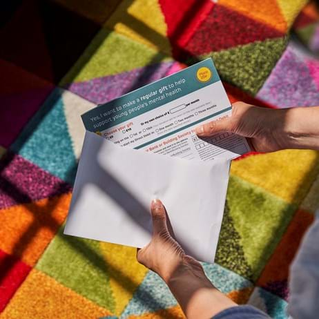 Person putting a donation into an envelope