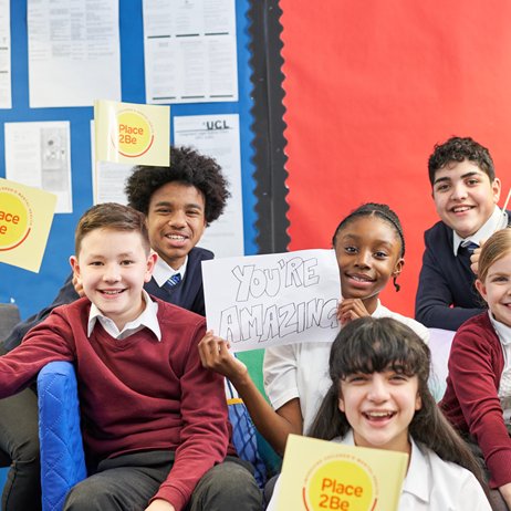Children holding Place2Be flags with a sign saying "you're amazing"