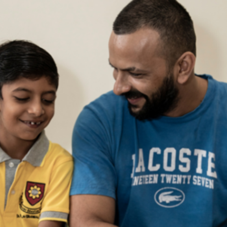 Dad sitting with son looking at homework