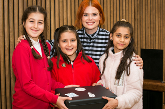 Three pupils from Upton Cross Primary School, and Lindsey Russell, holding the time capsule