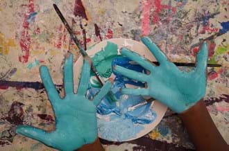 Children's hands with blue paint on them