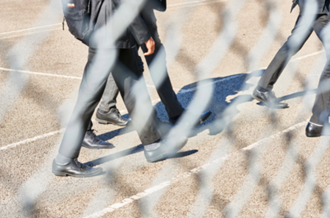 abstract view through school gate wire of school children walking