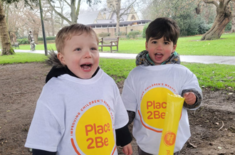Two young children wearing Place2Be t-shirts whilst on a sponsored walk for Little Step Out for Mental Health