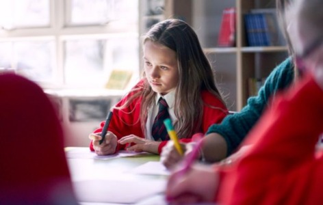 school pupil sat at classroom desk