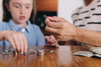 Adult and female child counting coins and money