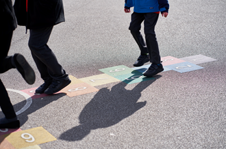 children playing hopscotch on school playground