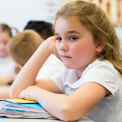 School girl sitting at a table with books