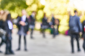 blurred image of secondary aged students on a playground