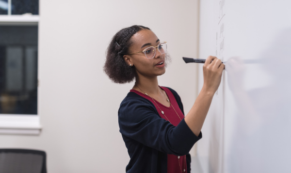 Teacher writing on whiteboard