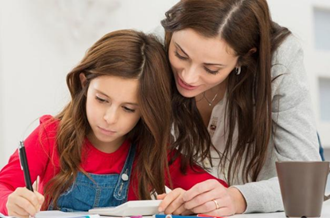 Mother and daughter doing homework on large table