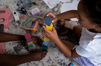 A child and parent sitting at home playing with building blocks.
