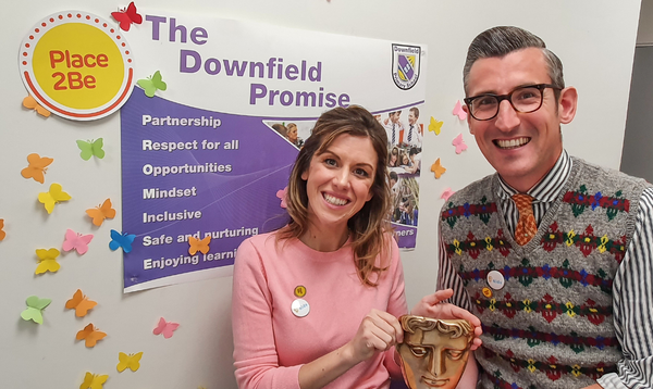 Ben Shires and Jenny Lawrence holding a BAFTA during a visit to Downfield Primary School