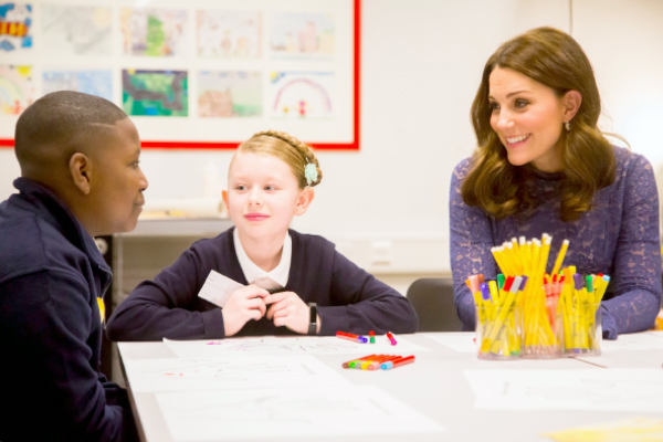 HRH Duchess of Cornwall and Cambridge sitting with school children