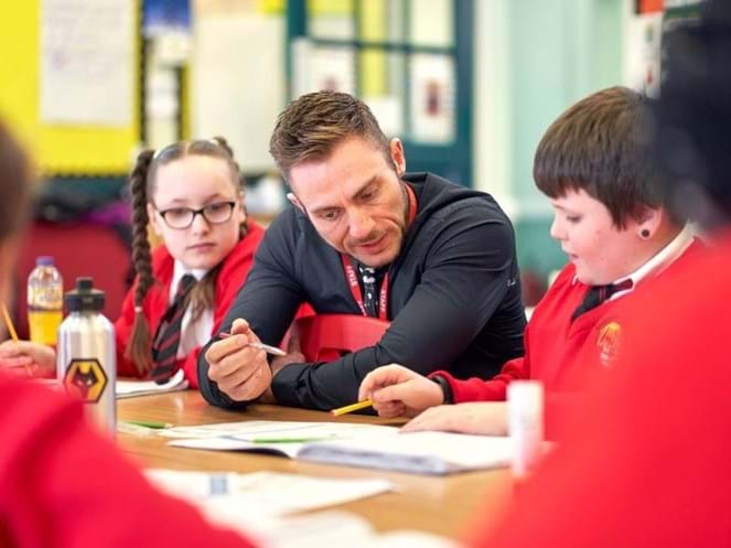 counsellor sitting school children at school table