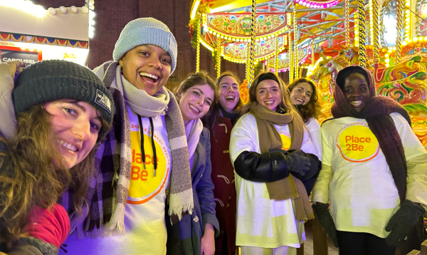 The Place2Be fundraising team at Christmas at Battersea Power Station's ice skating rink. They are all looking into the camera and smiling.