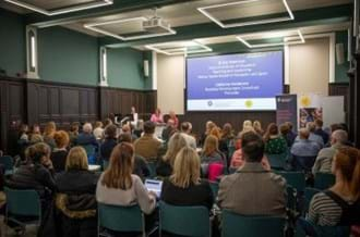 A group of people sitting in a room. They are watching and listening to a presentation delivered by Moray House and Place2Be. They have their backs to the camera.