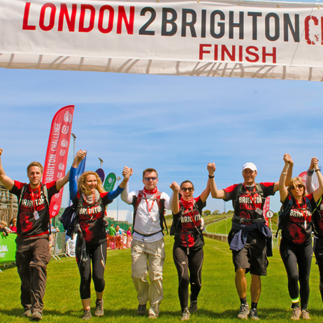 Group walking under London 2 Brighton banner