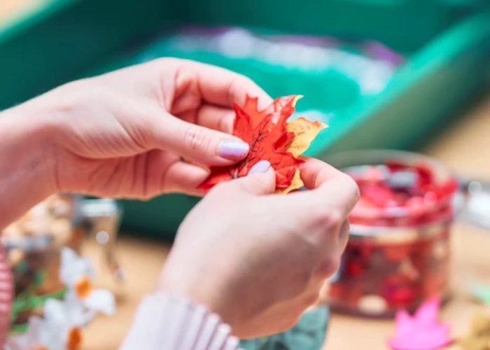 Adult using leaves in a crafty activity