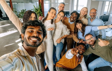 People in a work place smiling at the camera