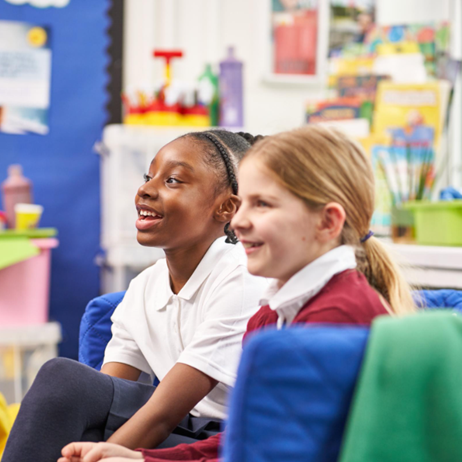 School girls sitting and smiling in a classroom