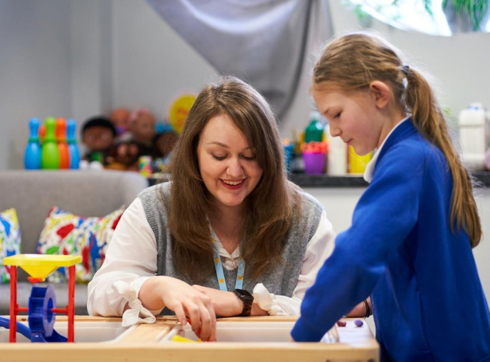 A Place2Be school counsellor playing with a student