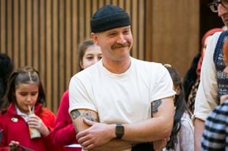 Ricky Martin smiling and laughing with pupils and teachers.