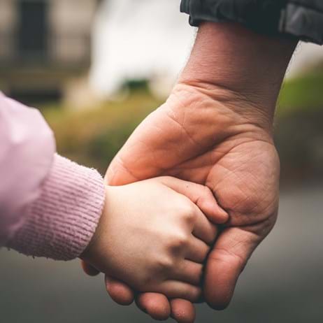Child and adult holding hands