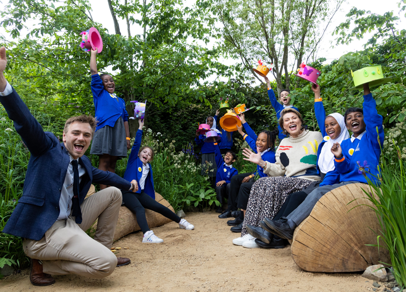 Jamie Butterworth, Kate Silverton, and pupils from Viking Primary School cheering in the garden