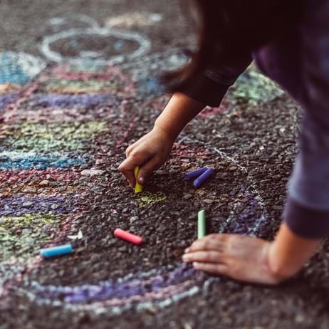 Child drawing on the ground in chalk